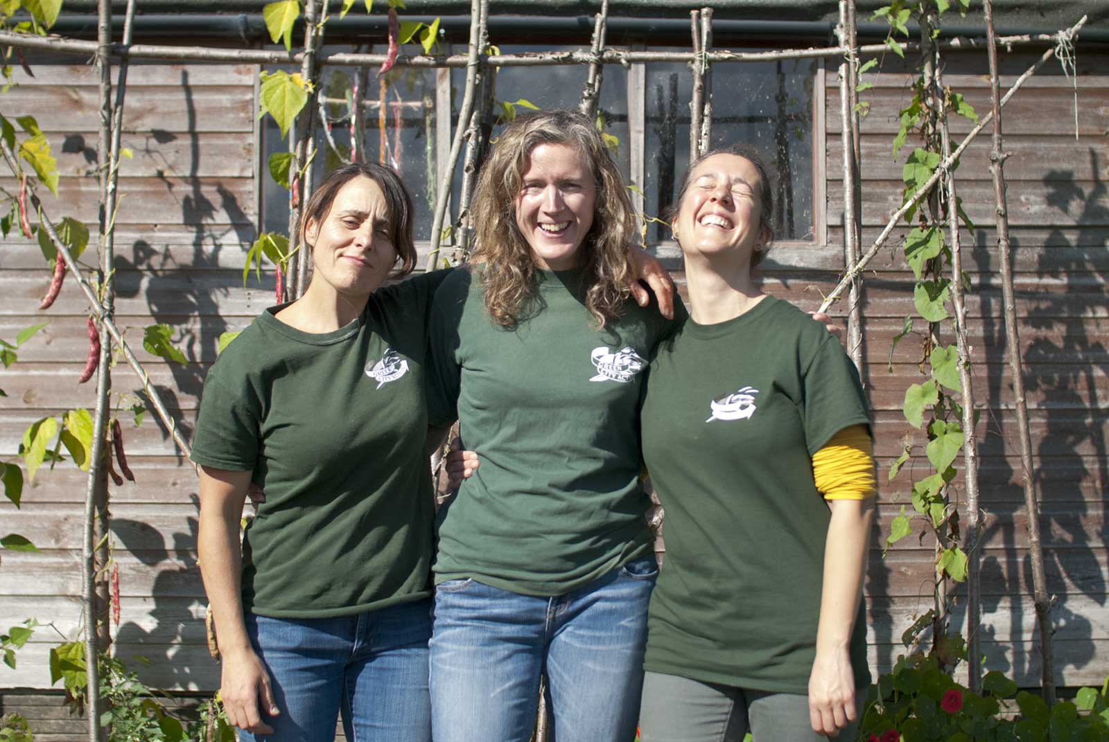 photo of three women Saskia, Hazel and Jenny, the core team of Green City Action smiling at you at an allotment during summer